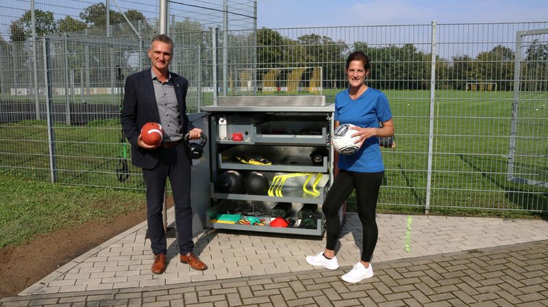 Bürgermeister Frank Rombey und Sabine Wenzel von „bee-fit“ präsentieren die SportBox