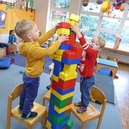 Zwei Kinder bauen einen Turm aus Riesen-Legosteinen