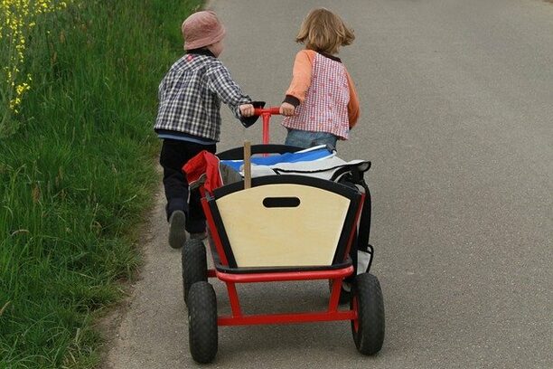 Zwei Kinder mit dem Bollerwagen