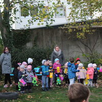 Kindergartenkinder auf dem Gelände mit Laternen