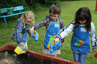 Kinder gießen die pflanzen